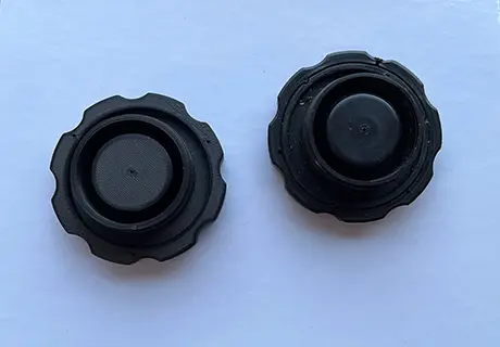 A pair of black knobs on top of a table.